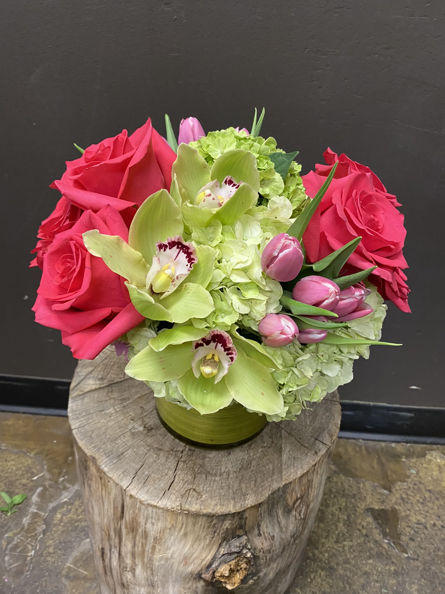 Pink roses and green orchids in a low vase arrangement