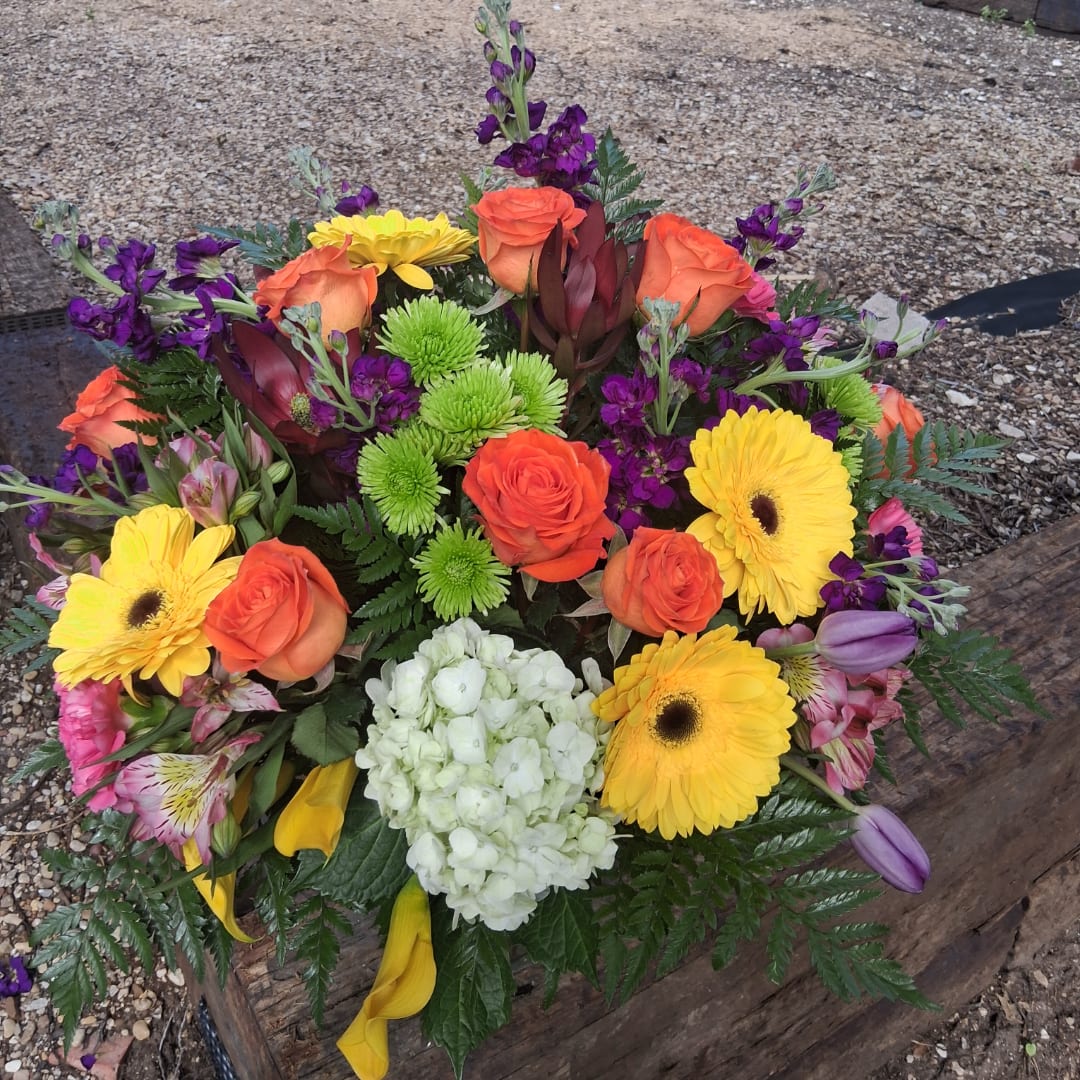 Colorful mixed bouquet with orange roses, yellow gerberas, and white hydrangea