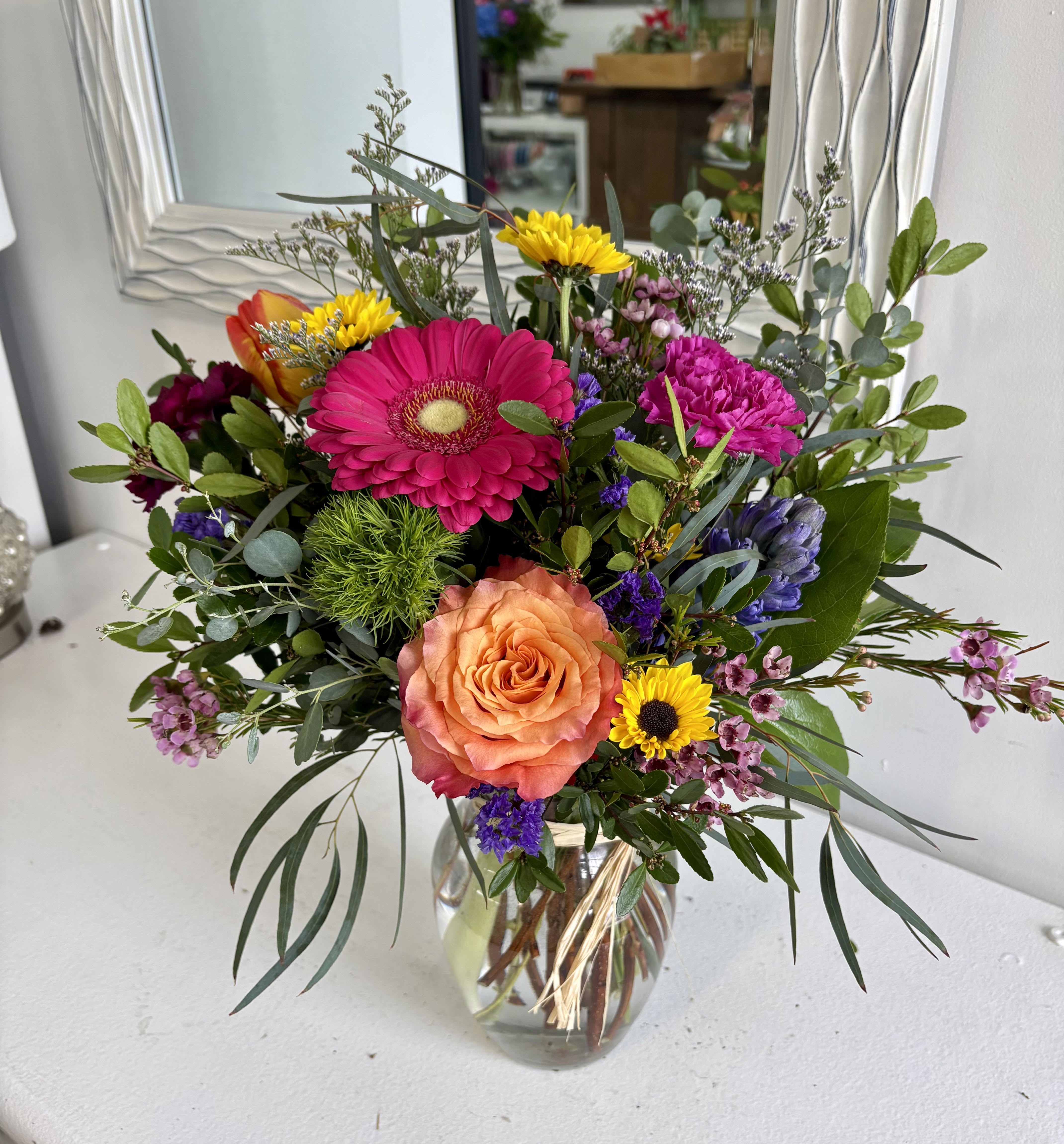 Spring Radiance - Spring Radiance is a vibrant celebration of color and freshness, designed to brighten any space with effortless charm. Bursting with lively spring tones and rich texture, this arrangement brings together a joyful mix of blooms and greenery for a fresh, uplifting look. Perfect for adding a pop of seasonal beauty to your home or gifting a little sunshine to someone special.