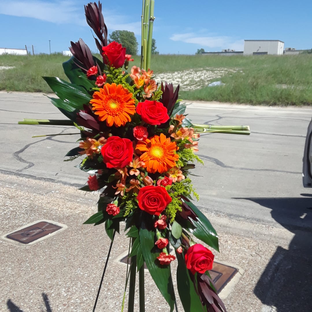 Tall floral standing spray with red roses and orange gerbera daisies