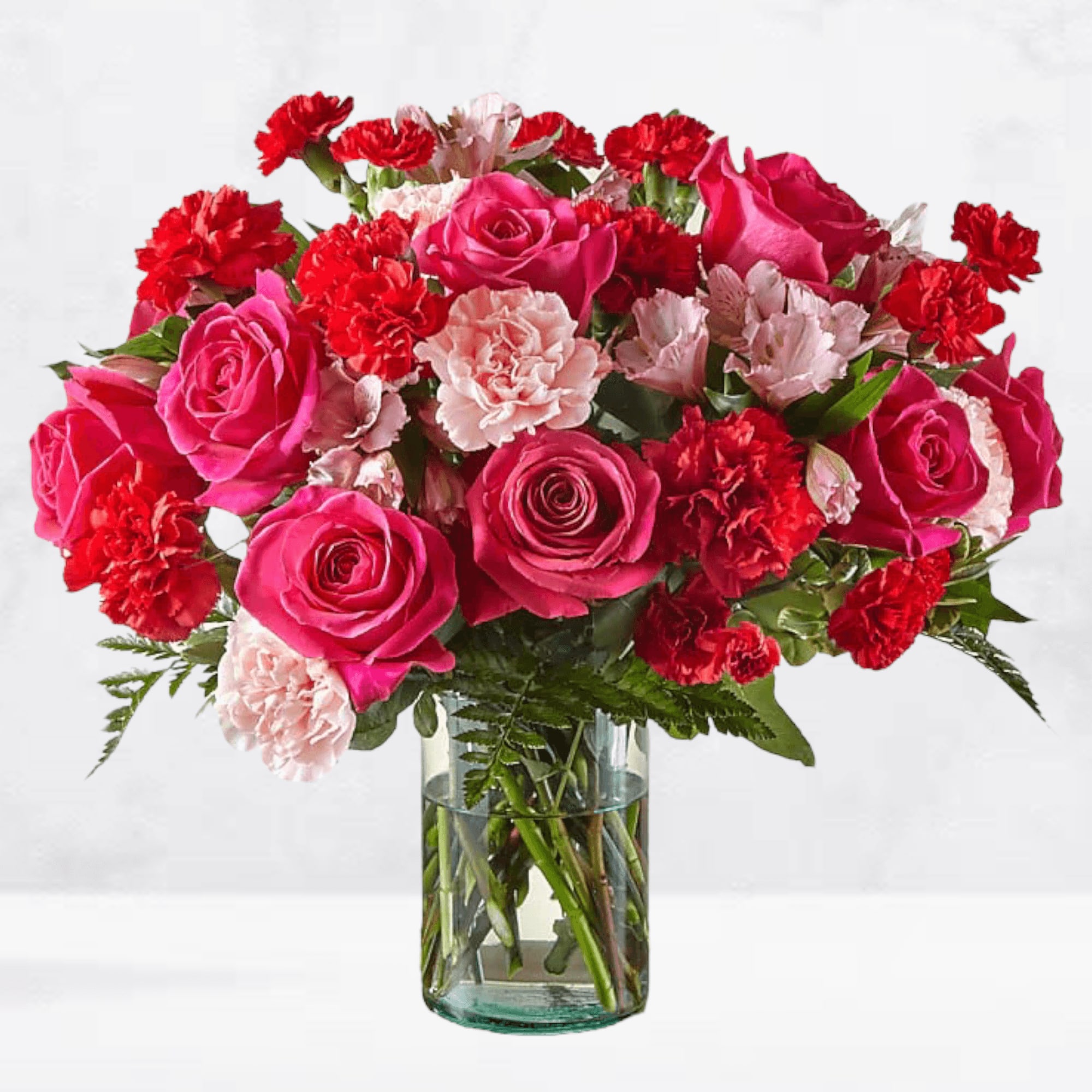 Pink roses and red carnations in a clear glass vase