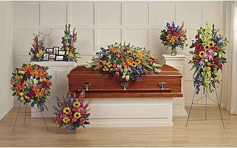 Casket surrounded by colorful funeral flower arrangements