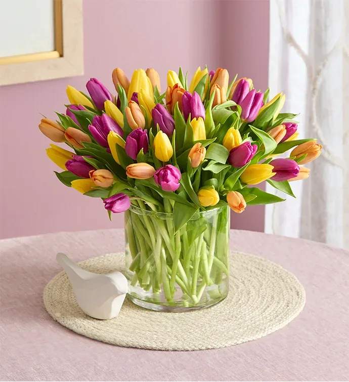 Bouquet of multicolored tulips in a clear glass vase