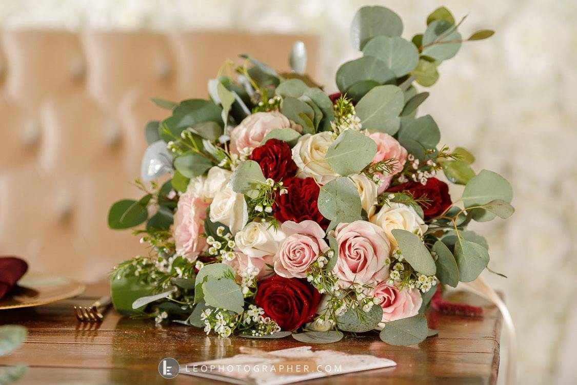 Bouquet of red, pink, and white roses with eucalyptus