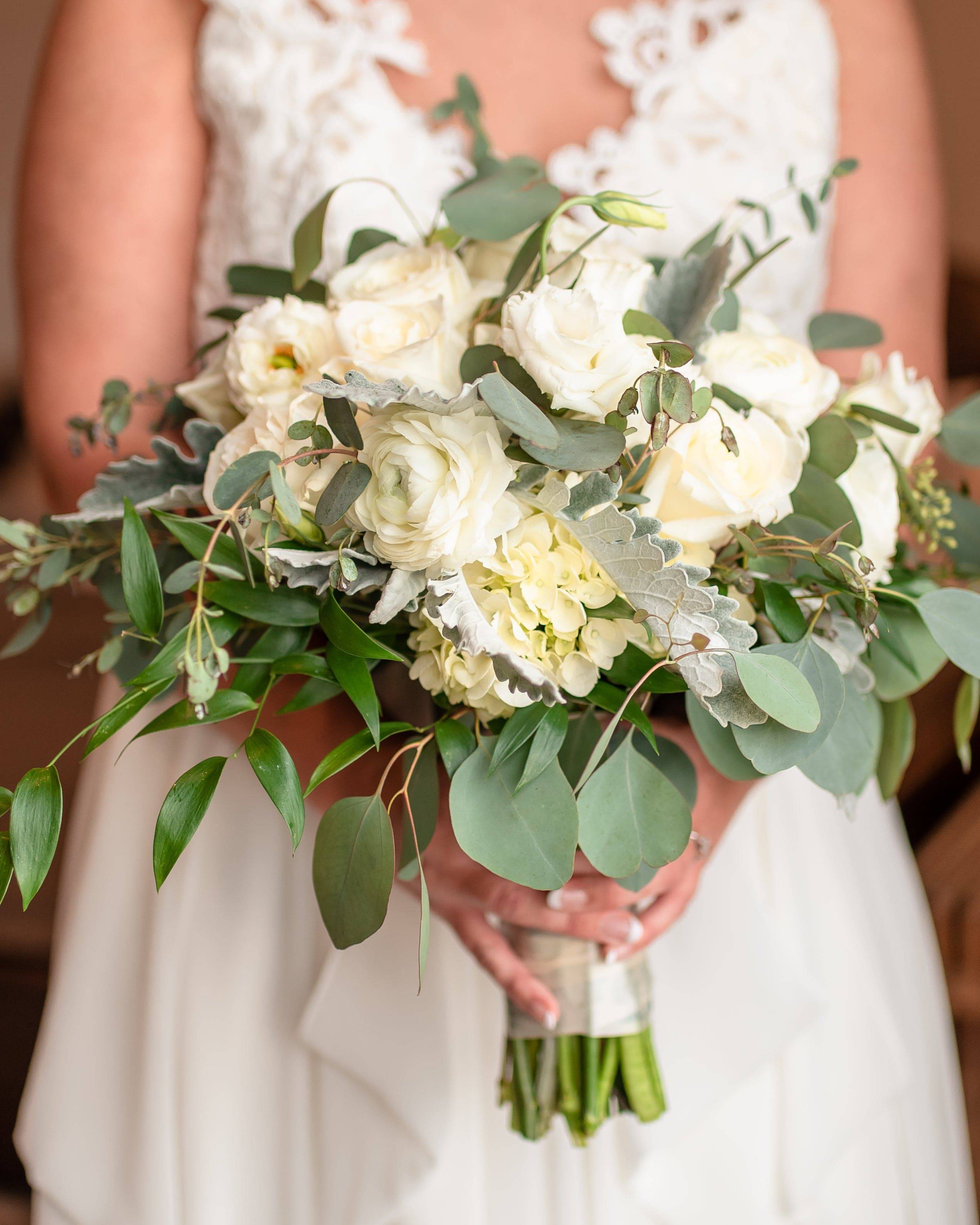 Bride holding a white bouquet with eucalyptus