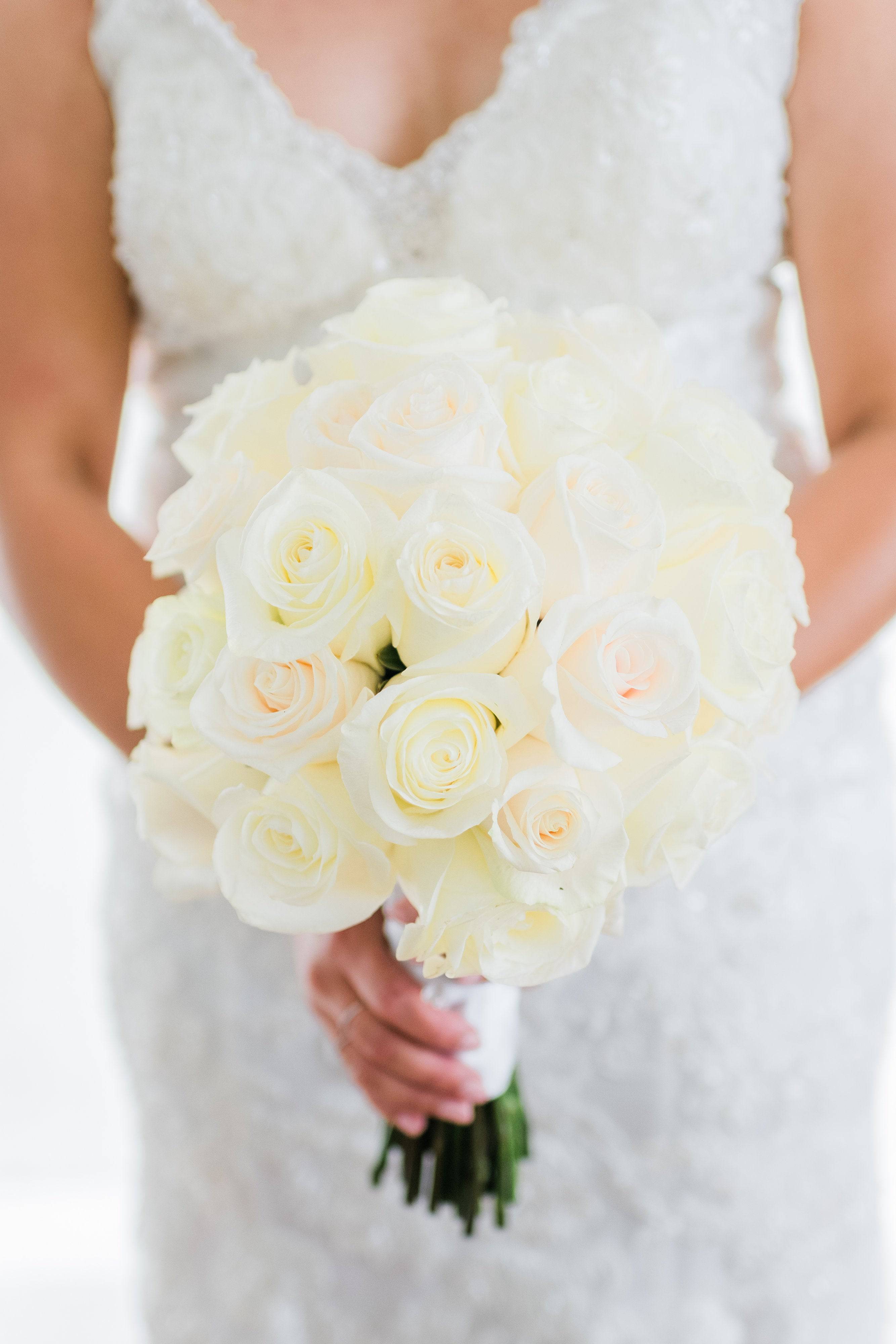Bride holding a bouquet of white roses