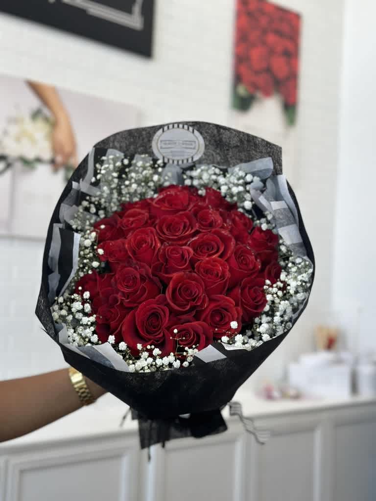 Bouquet of red roses with white baby's breath in black wrapping
