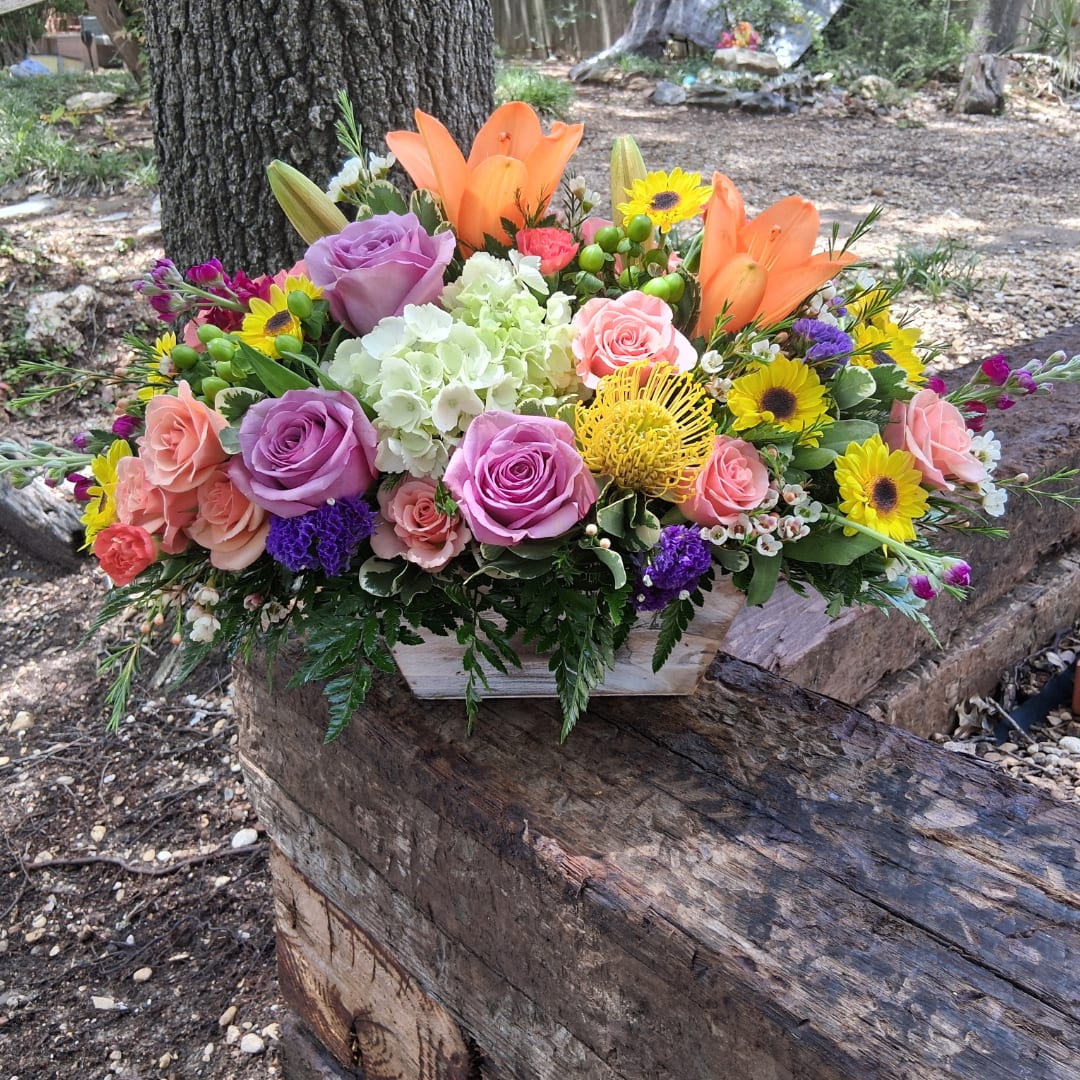 Colorful mixed flower arrangement in a rustic wooden box