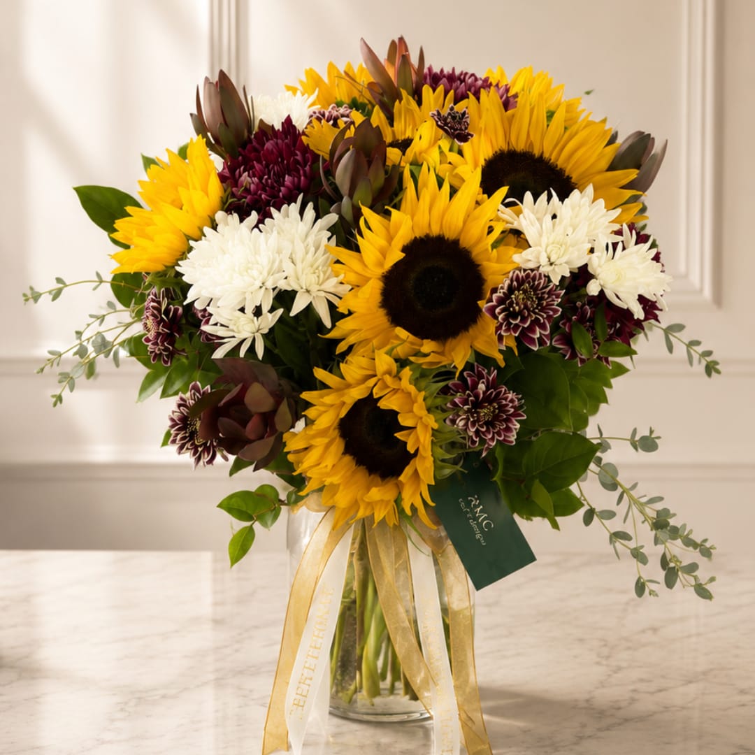 Bouquet of sunflowers and white chrysanthemums in a glass vase