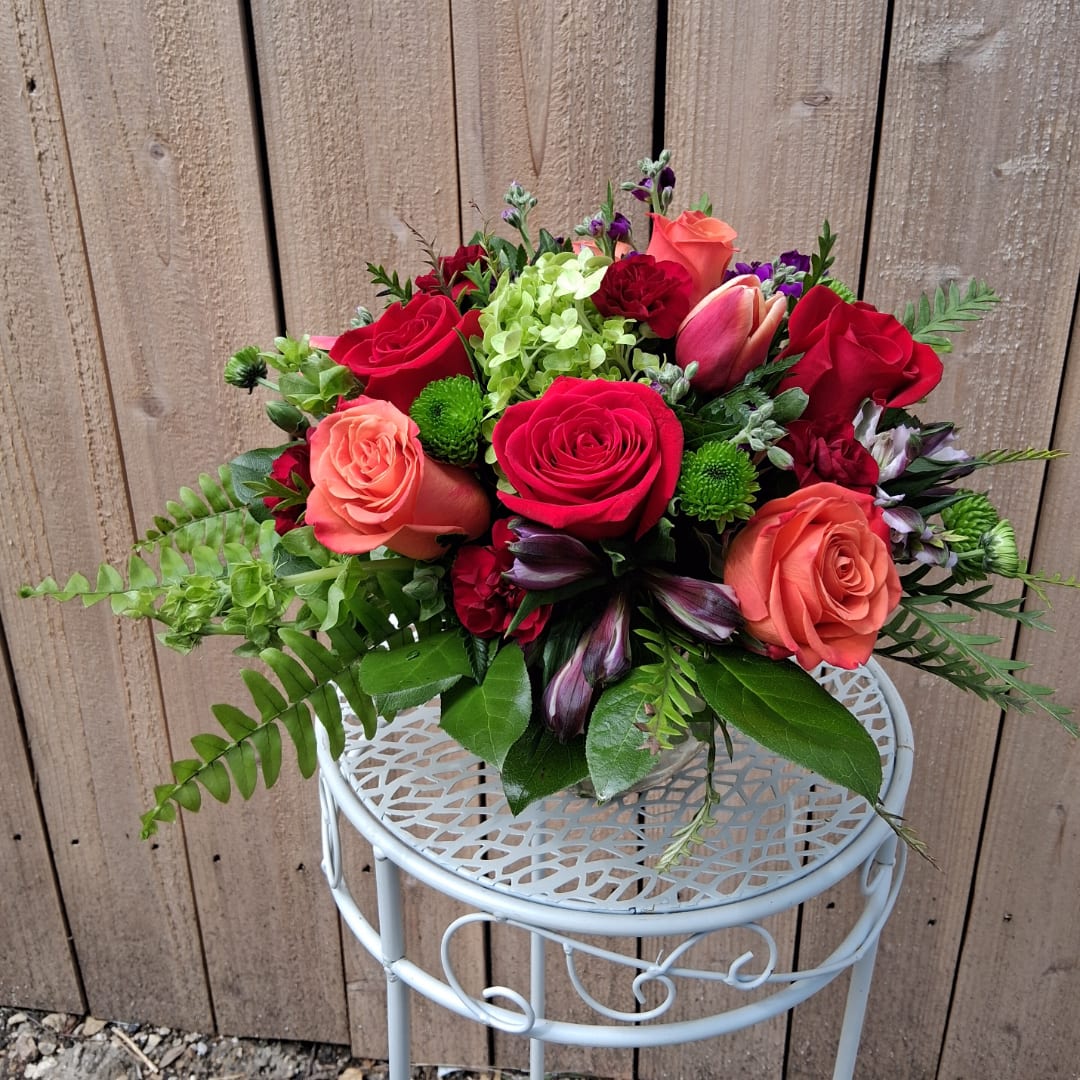Bouquet of red and coral roses with mixed greenery