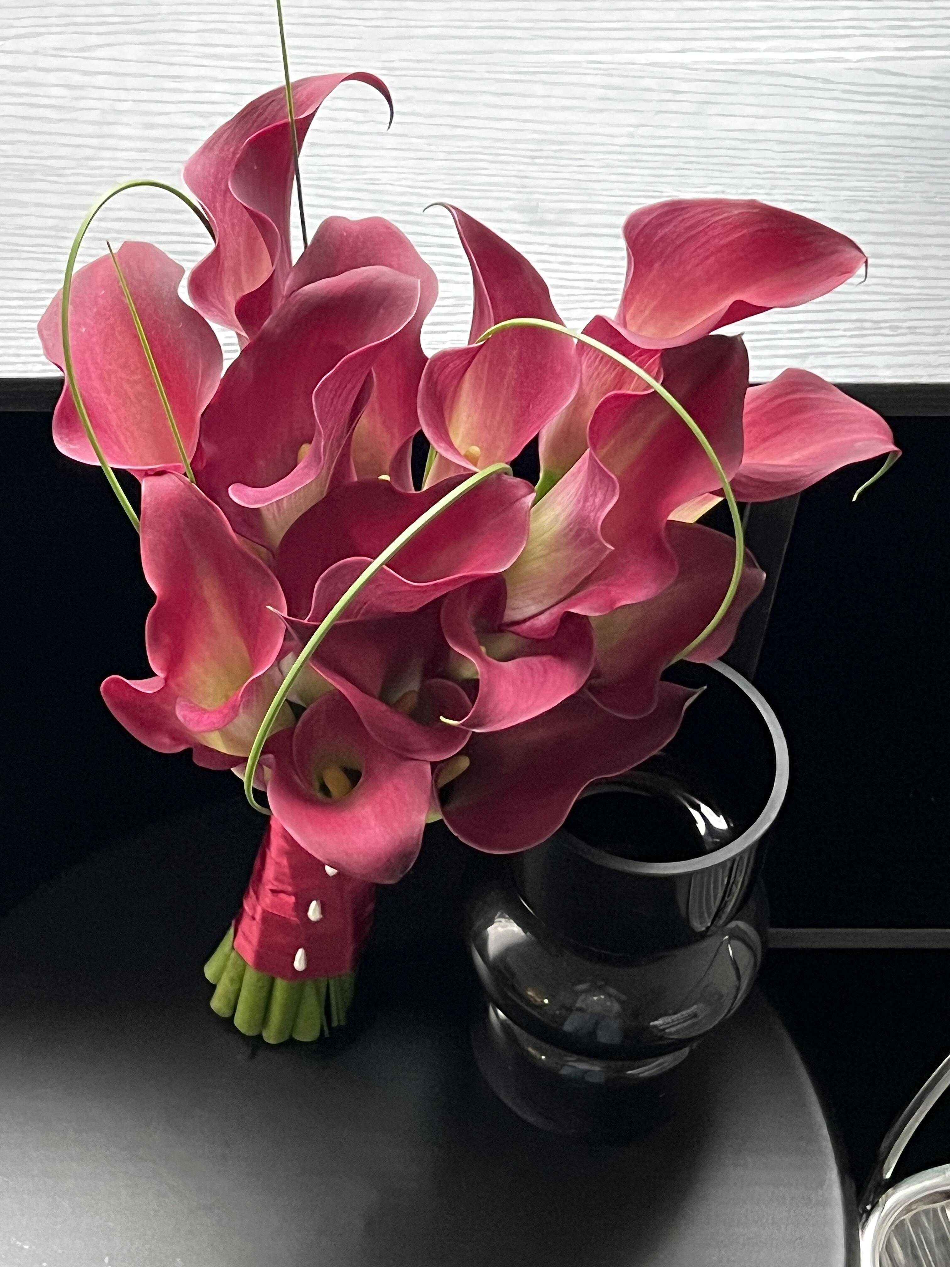 Bouquet of pink calla lilies with a black vase