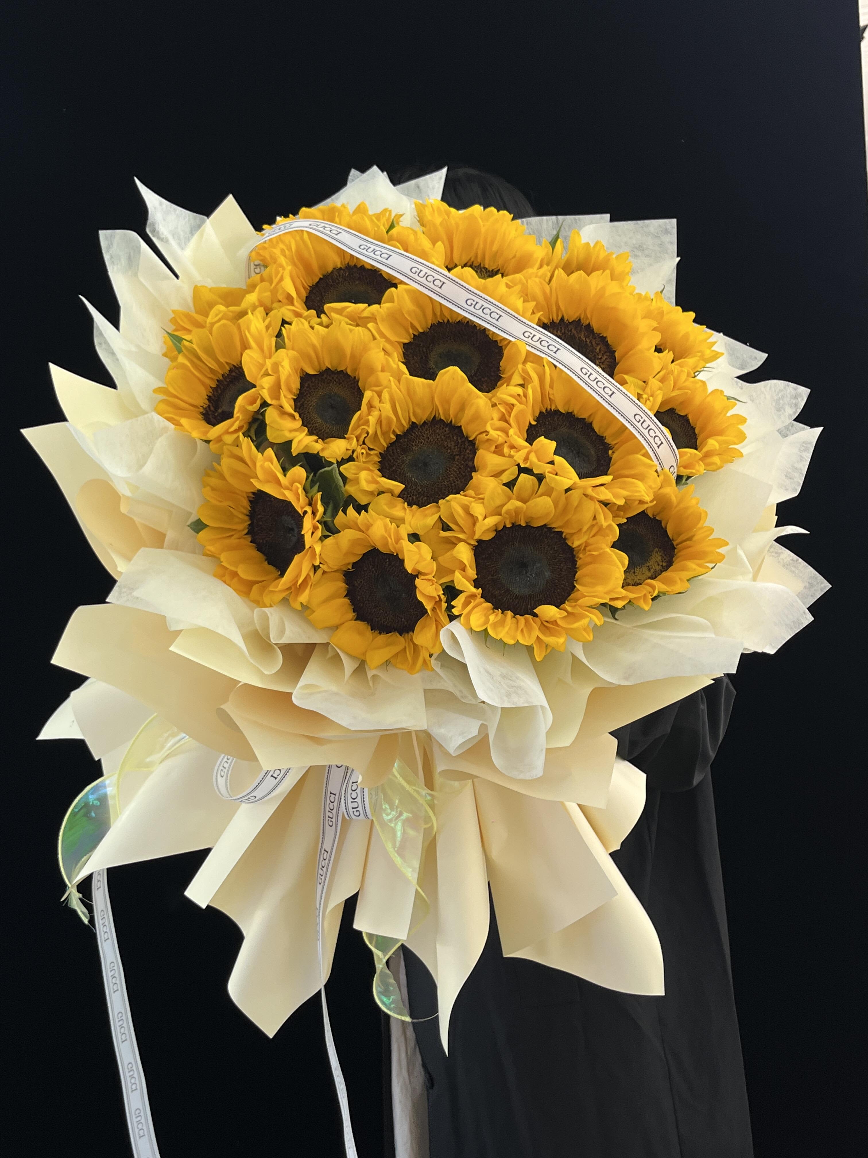 Bouquet of sunflowers wrapped in cream paper with a ribbon