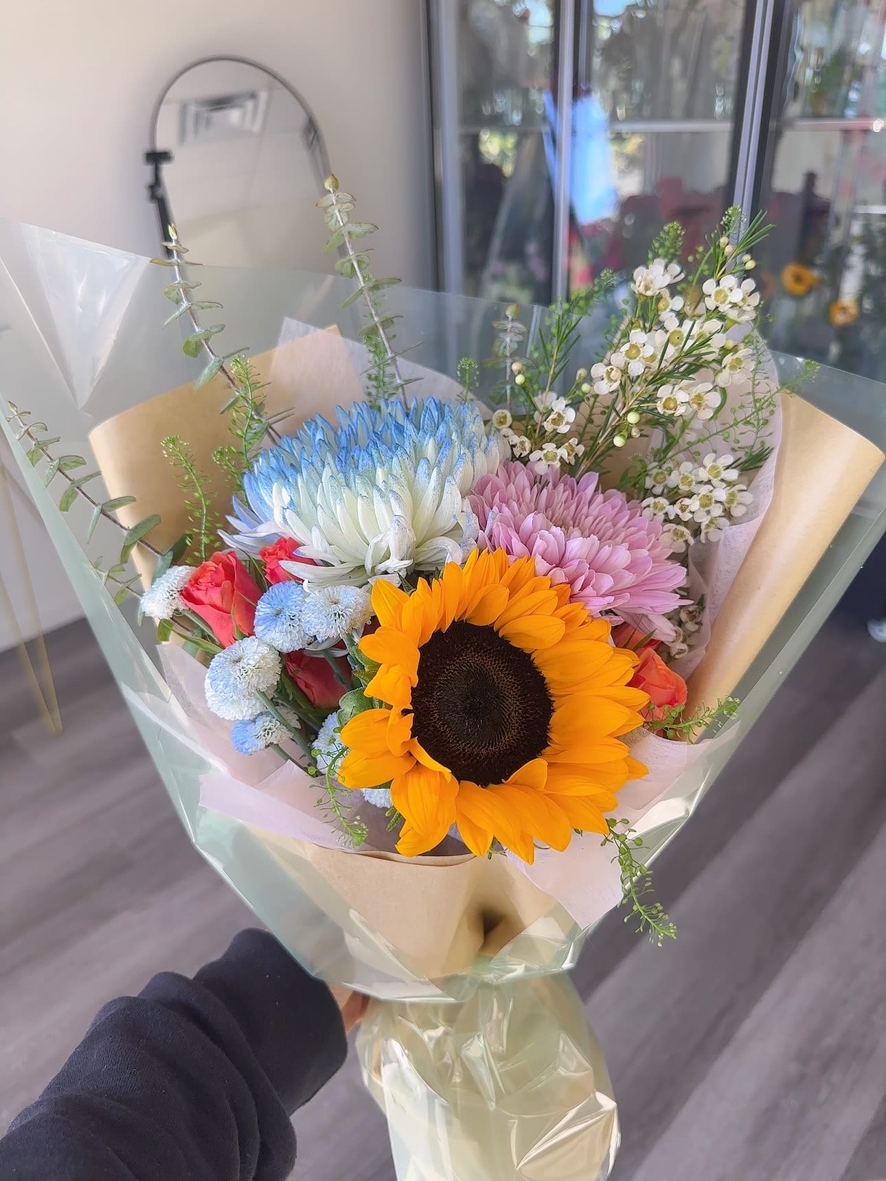 Bouquet with a sunflower, pastel chrysanthemums, and small white blossoms