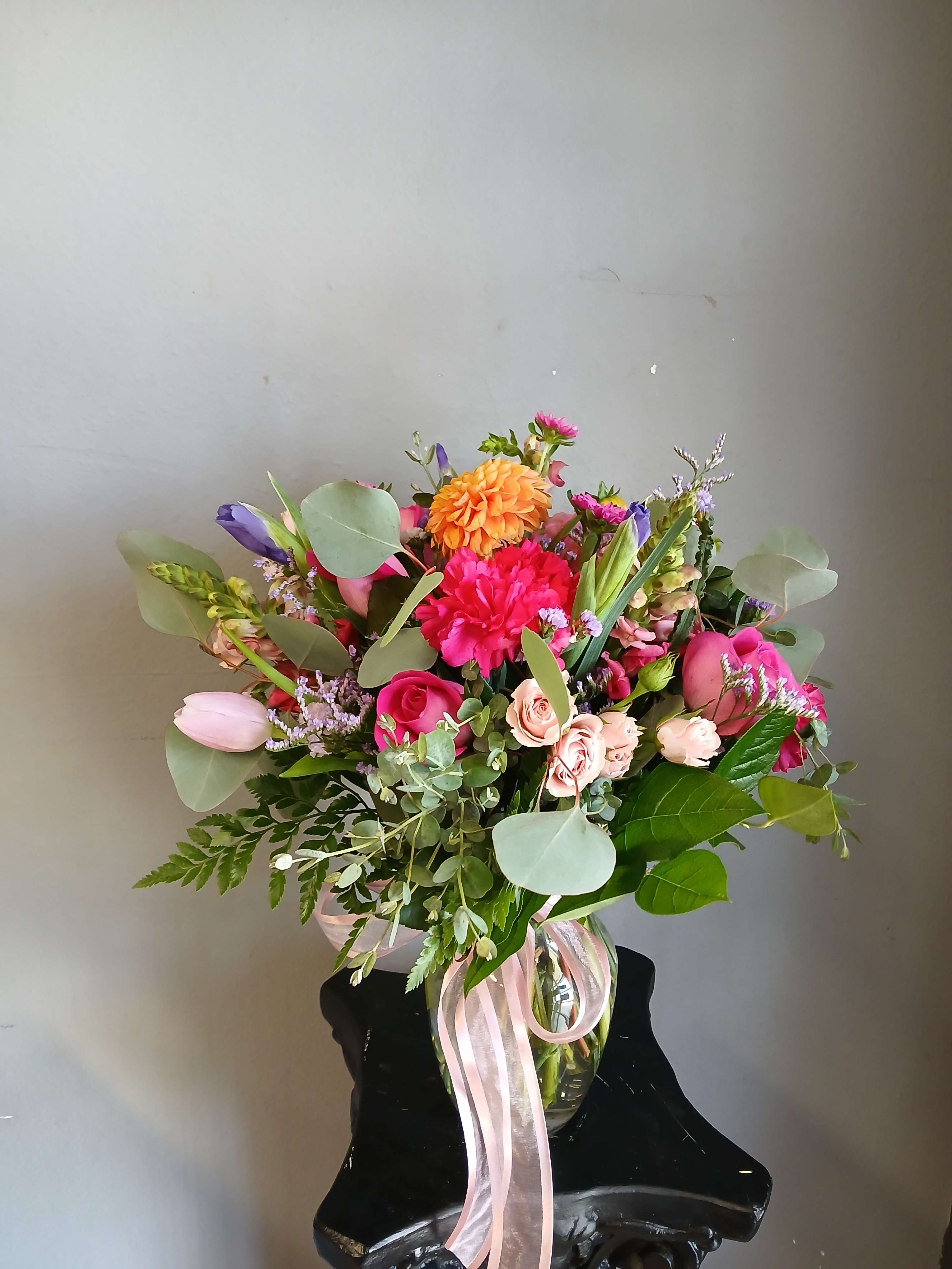 Mixed bouquet in a glass vase with pink, orange, and purple flowers