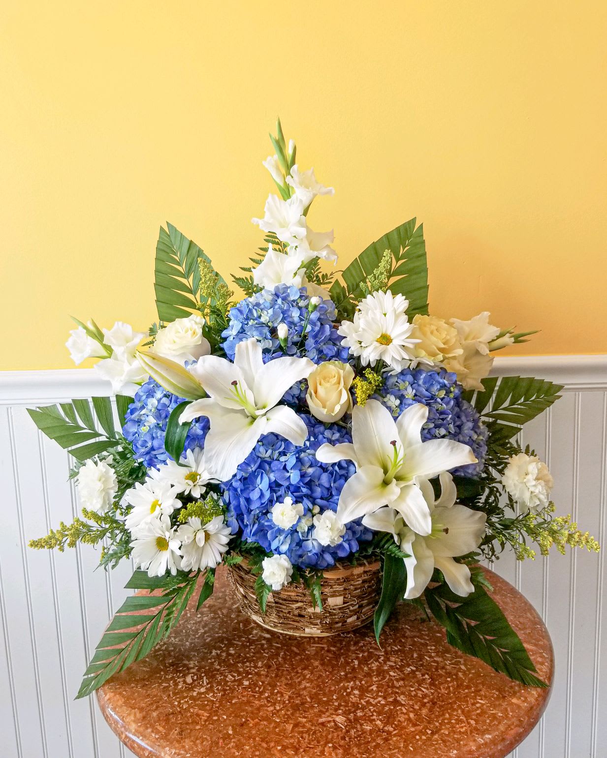 Sacred Garden Basket Arrangement - Our majestic blue and white basket arrangement will help honor their memory in a unique and meaningful way. Artistically designed by our expert florists with rich blue and pristine white blooms, this floral tribute is a heartfelt expression of your deepest sympathies.Approx dimensions 27in x 27in 