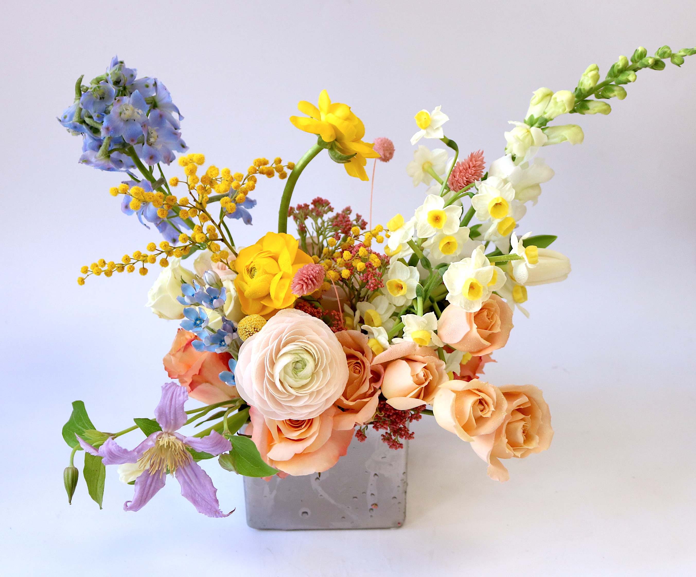 Mixed bouquet in a gray square vase with pastel flowers