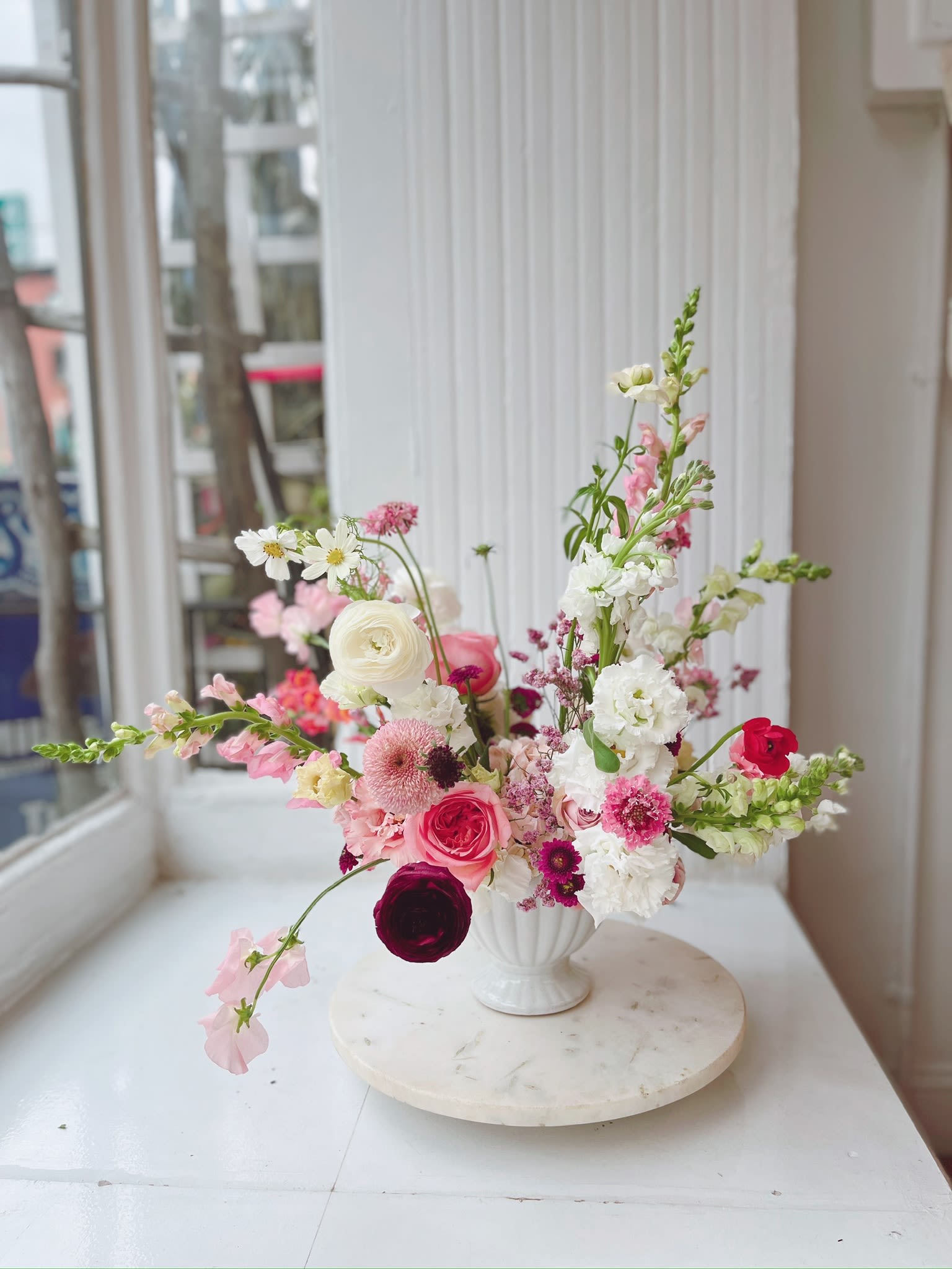 Pink and white mixed flower arrangement in a white vase