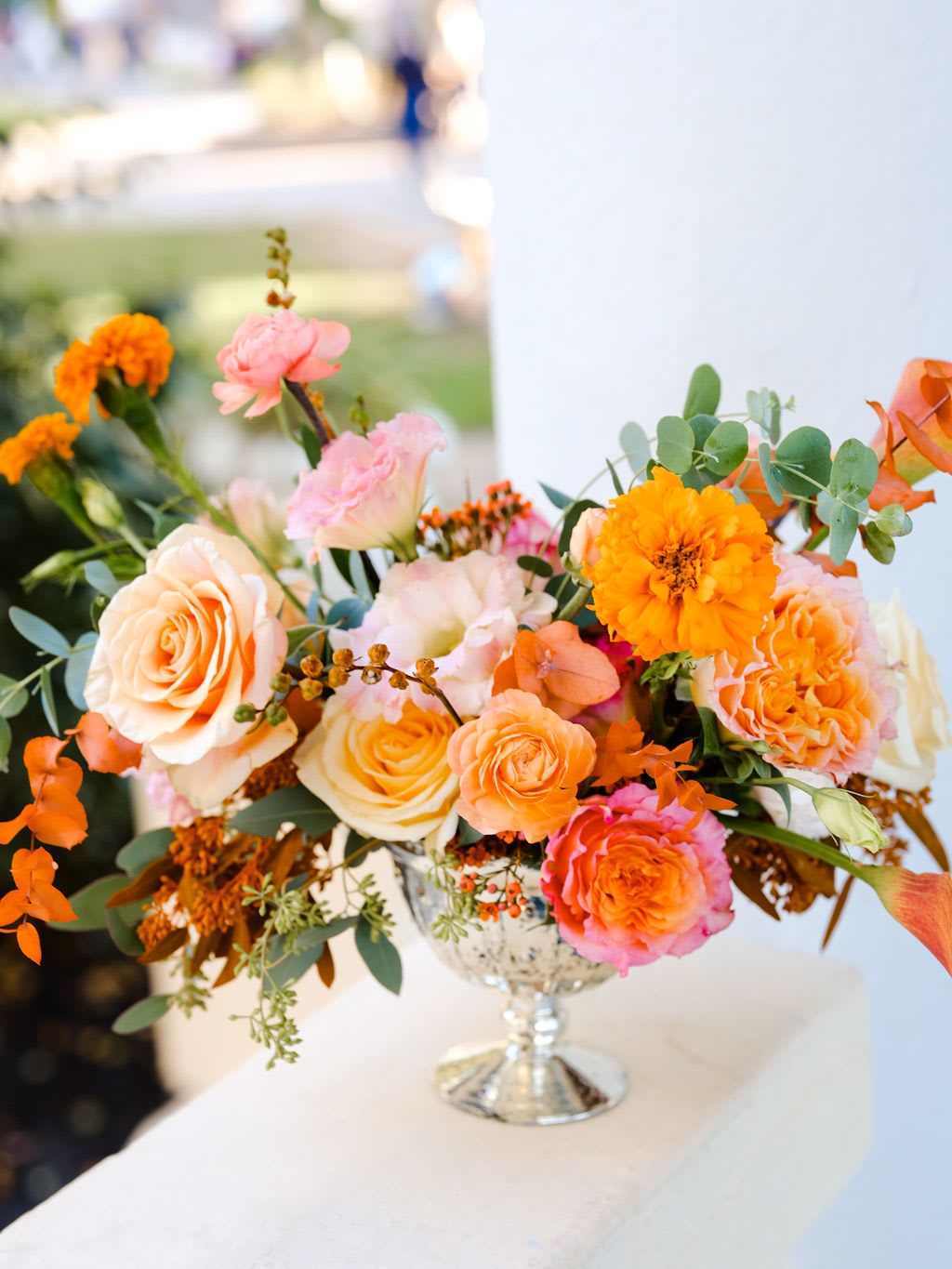 Orange Crush - Vibrant and warm, bursting with energetic orange hues that evoke the joy and gratitude of the season! Includes: roses, calla lilies, ranunculus, mums and seasonal foliage. Comes in a festive vase.