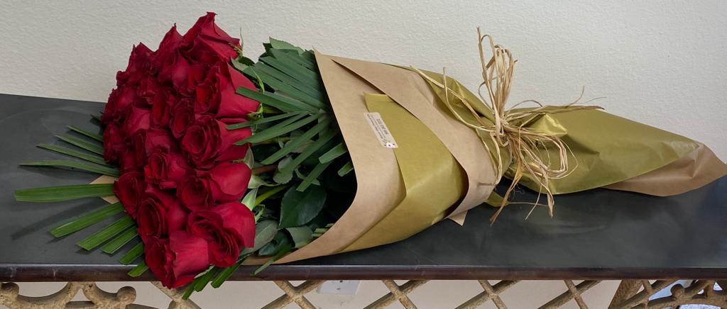 Bouquet of red roses wrapped in brown and gold paper