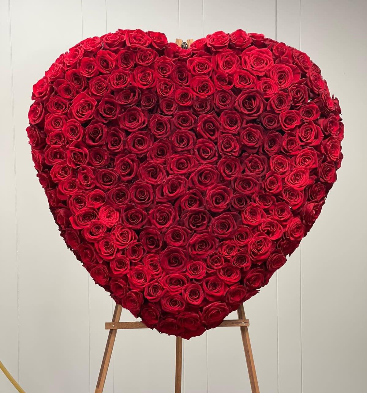 Heart-shaped arrangement of red roses on an easel