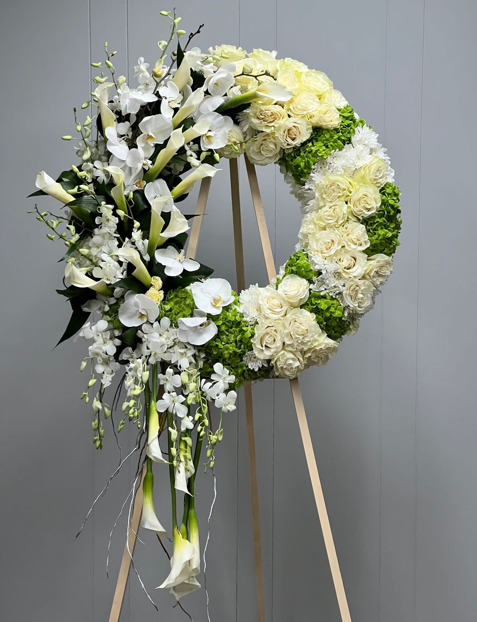 Large white floral wreath on a wooden easel