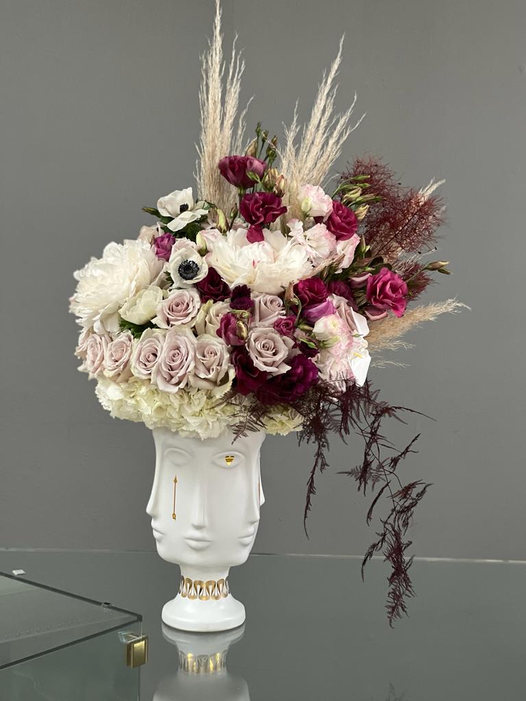 Floral arrangement in a white sculptural vase with pink and white blooms