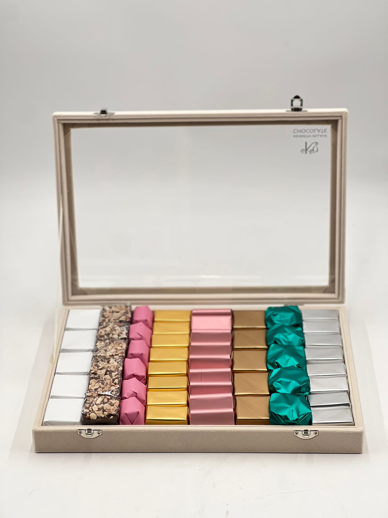 Open gift box with assorted wrapped chocolates in neat rows