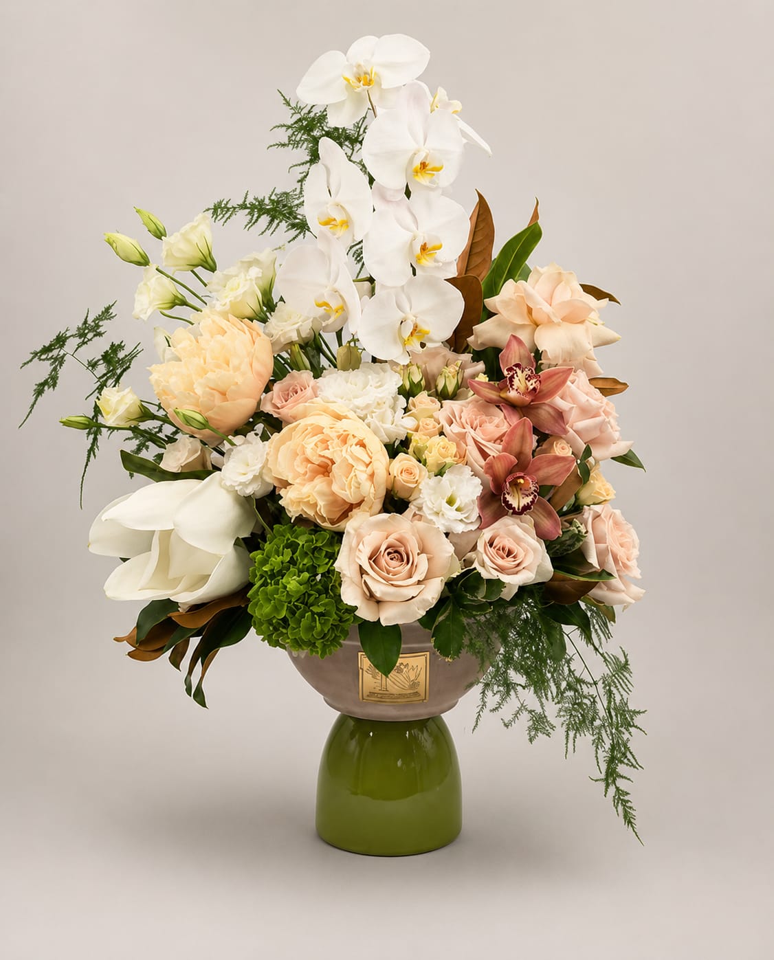 Garden of Grace - A luxurious floral arrangement featuring elegant white orchids, blush and champagne roses, peach-toned garden blooms. Designed in a sophisticated pedestal vase, this refined arrangement is perfect for birthdays, anniversaries, congratulations, or an unforgettable statement gift.