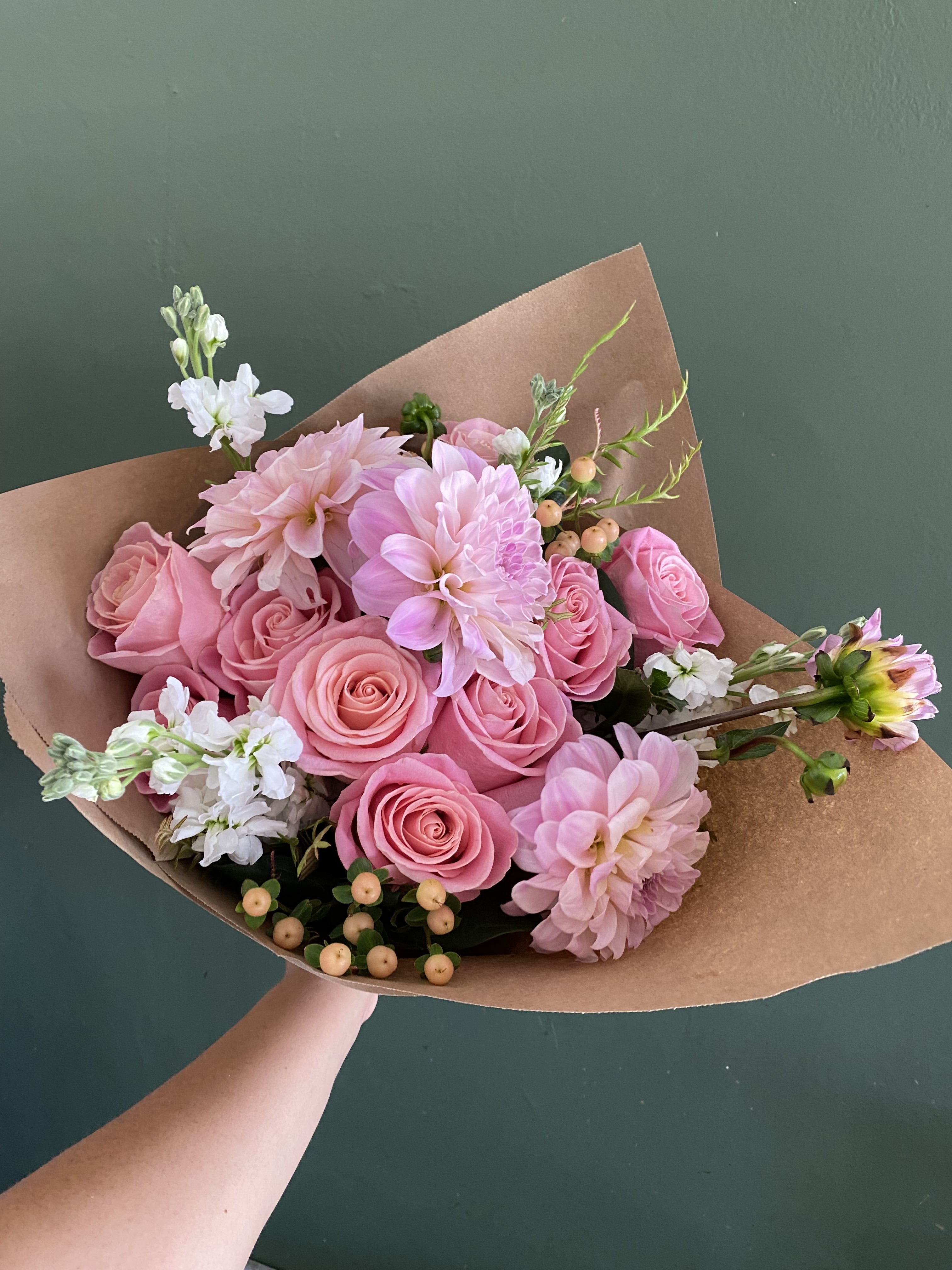 Pink rose and dahlia bouquet wrapped in brown paper
