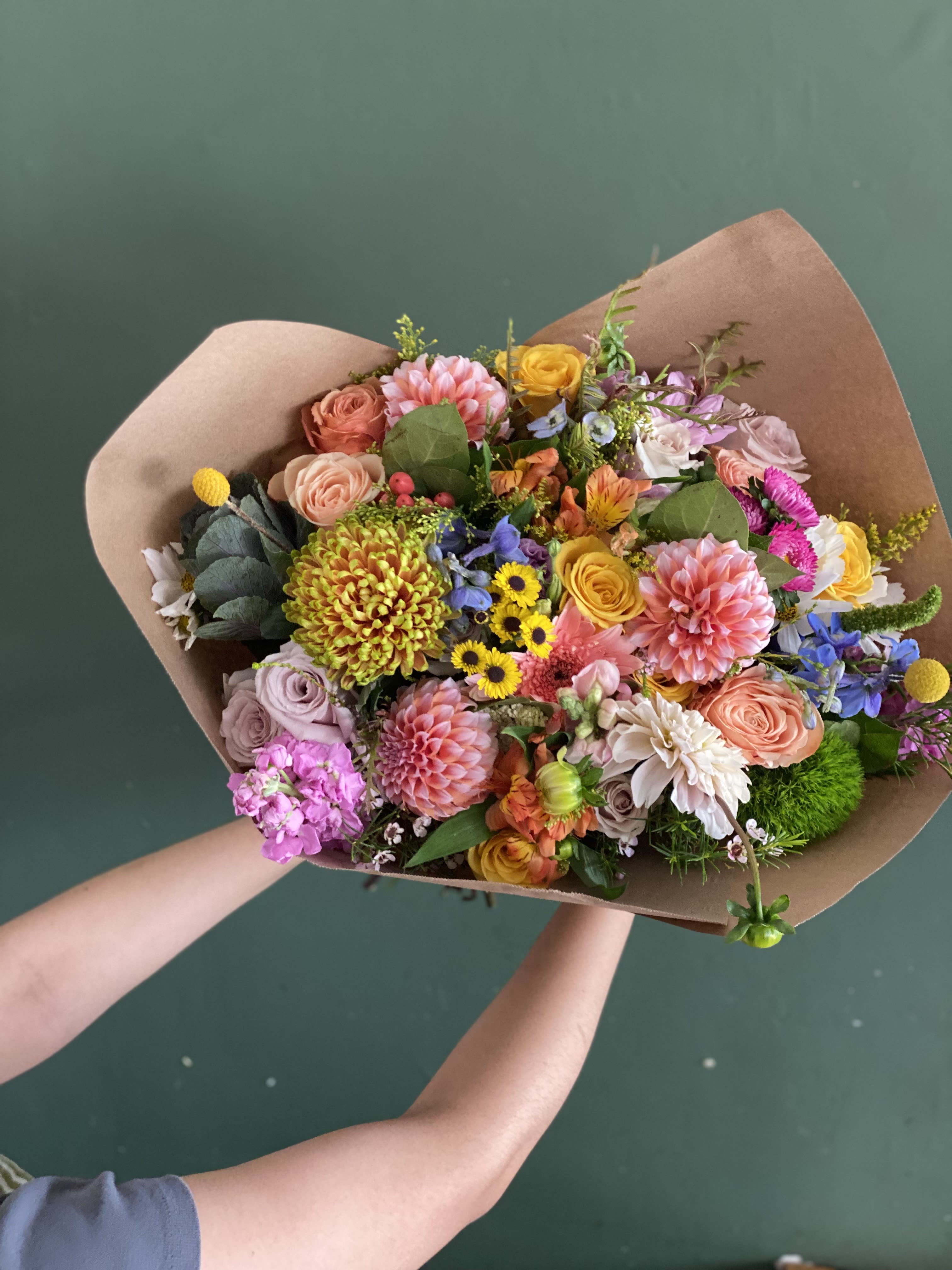 Mixed bouquet of colorful flowers wrapped in brown paper
