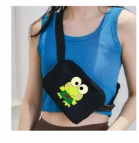Person wearing a black crossbody bag with a cartoon frog graphic