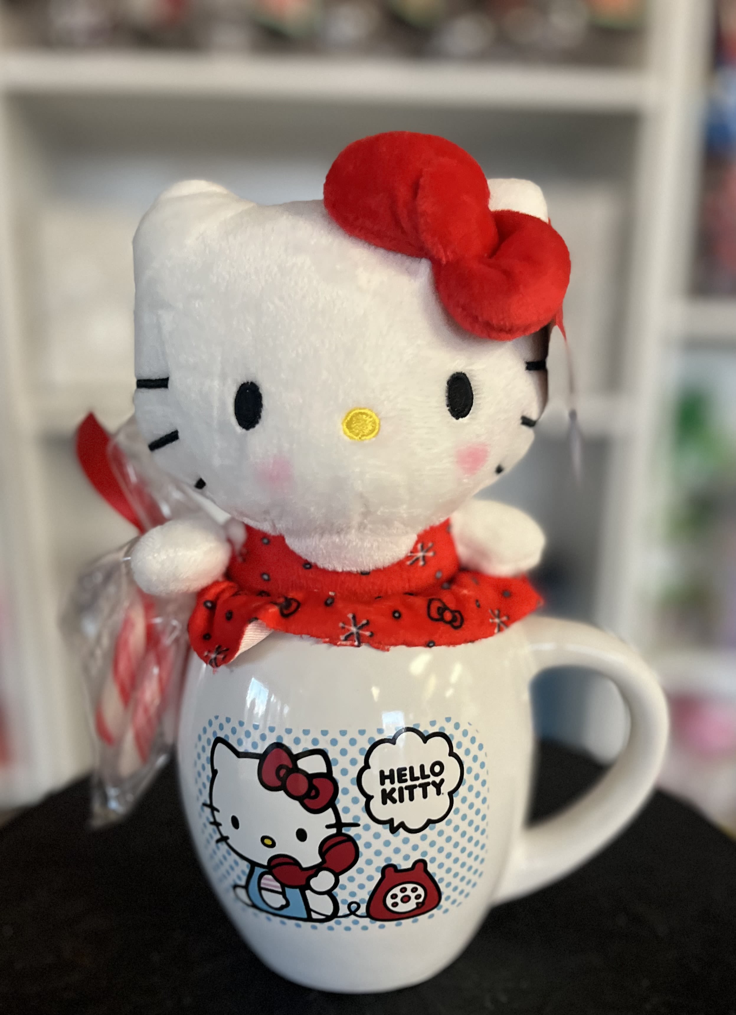 Hello Kitty plush sitting on a Hello Kitty mug