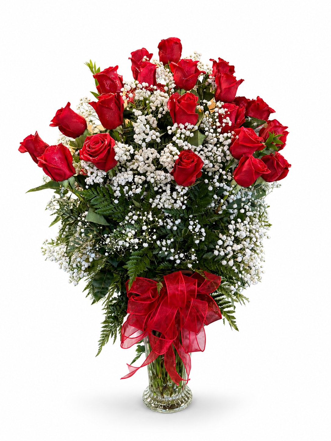 Red roses and baby's breath in a clear glass vase with a red ribbon