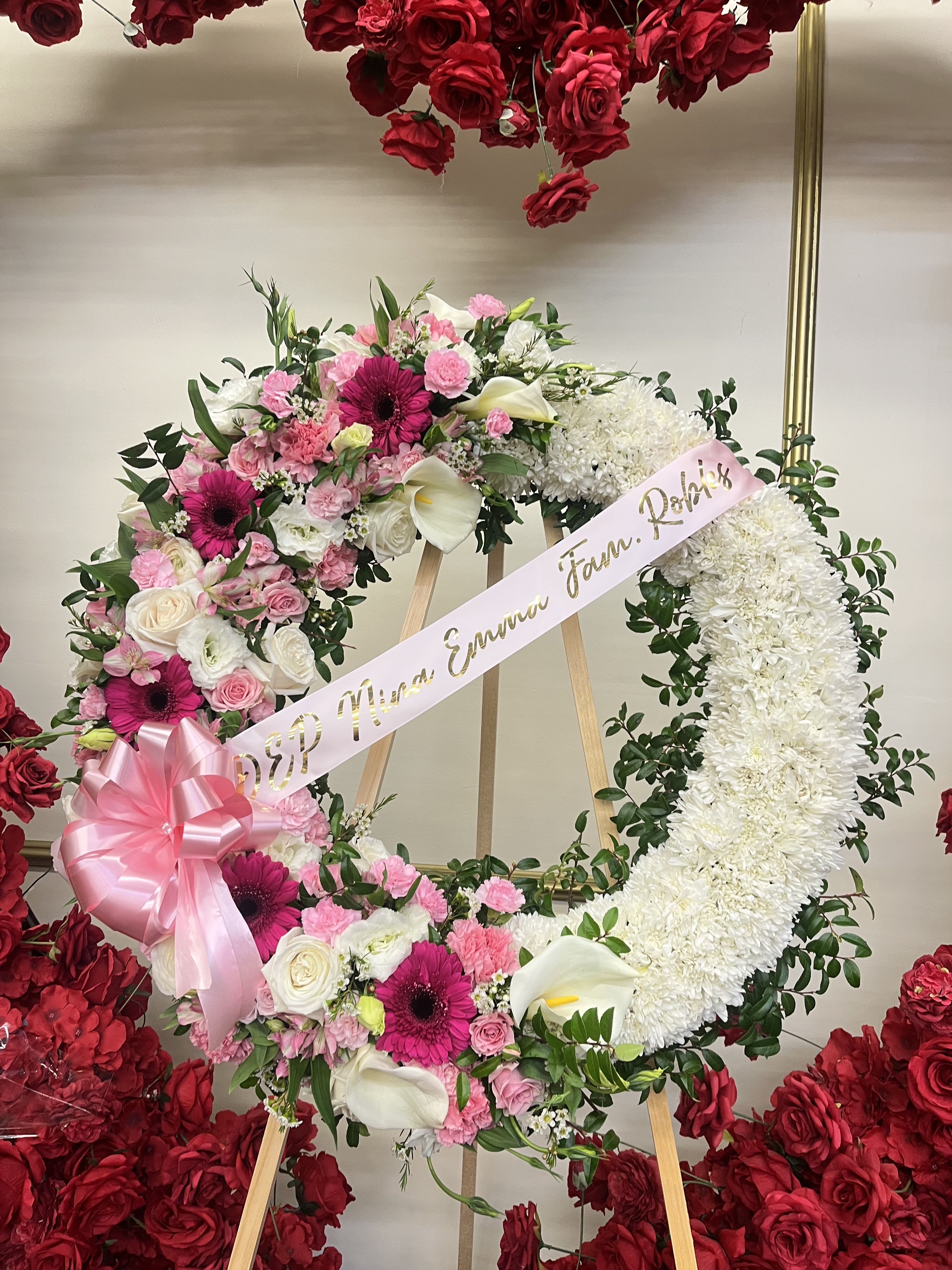 Large floral wreath with pink and white flowers on an easel