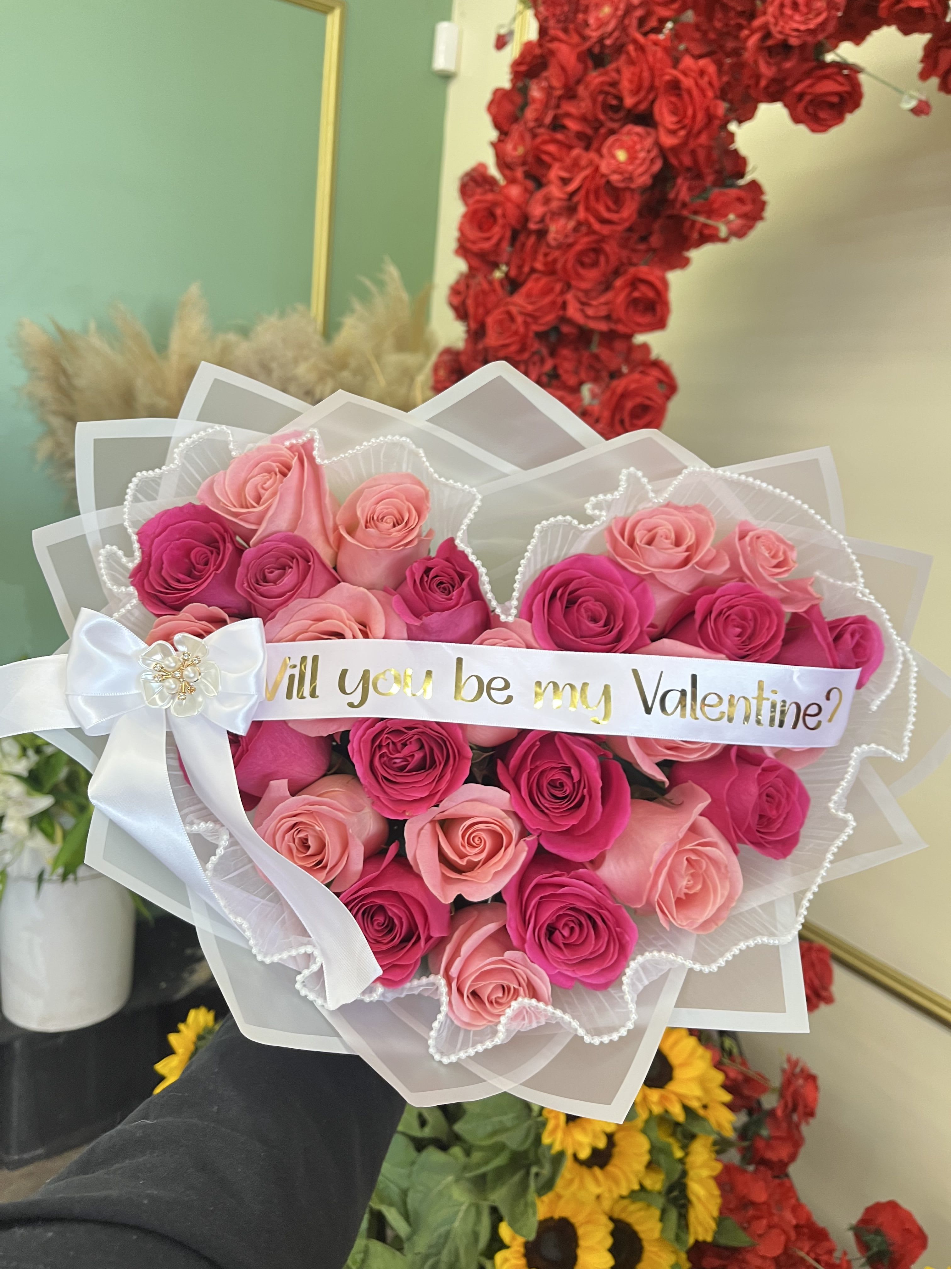 Pink and red rose bouquet with a "Will you be my Valentine?" ribbon