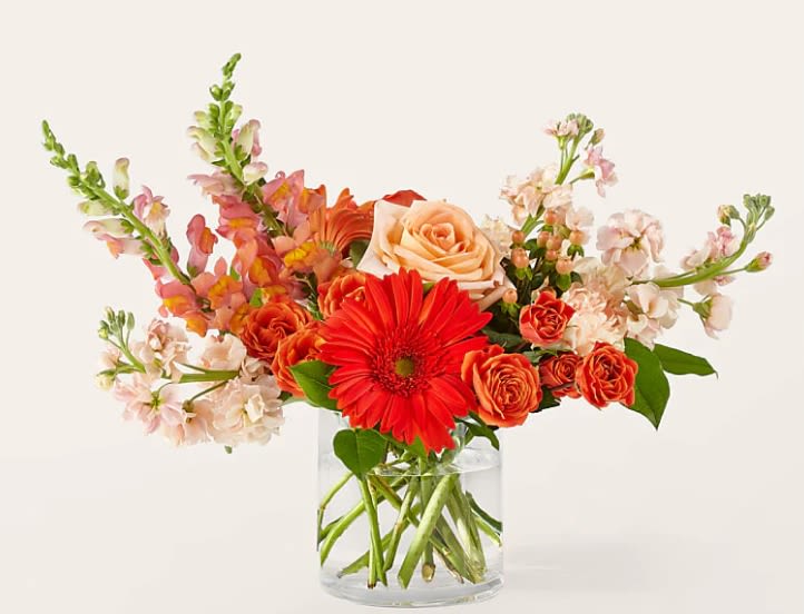 Orange and peach flowers in a clear glass vase