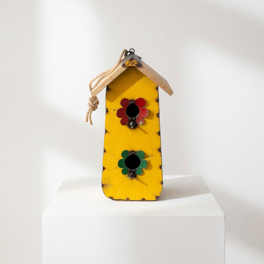 Yellow wooden birdhouse with red and green flower decorations