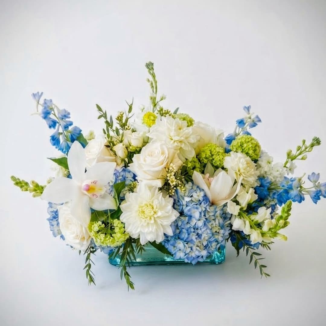 Blue and white floral arrangement in a turquoise glass vase