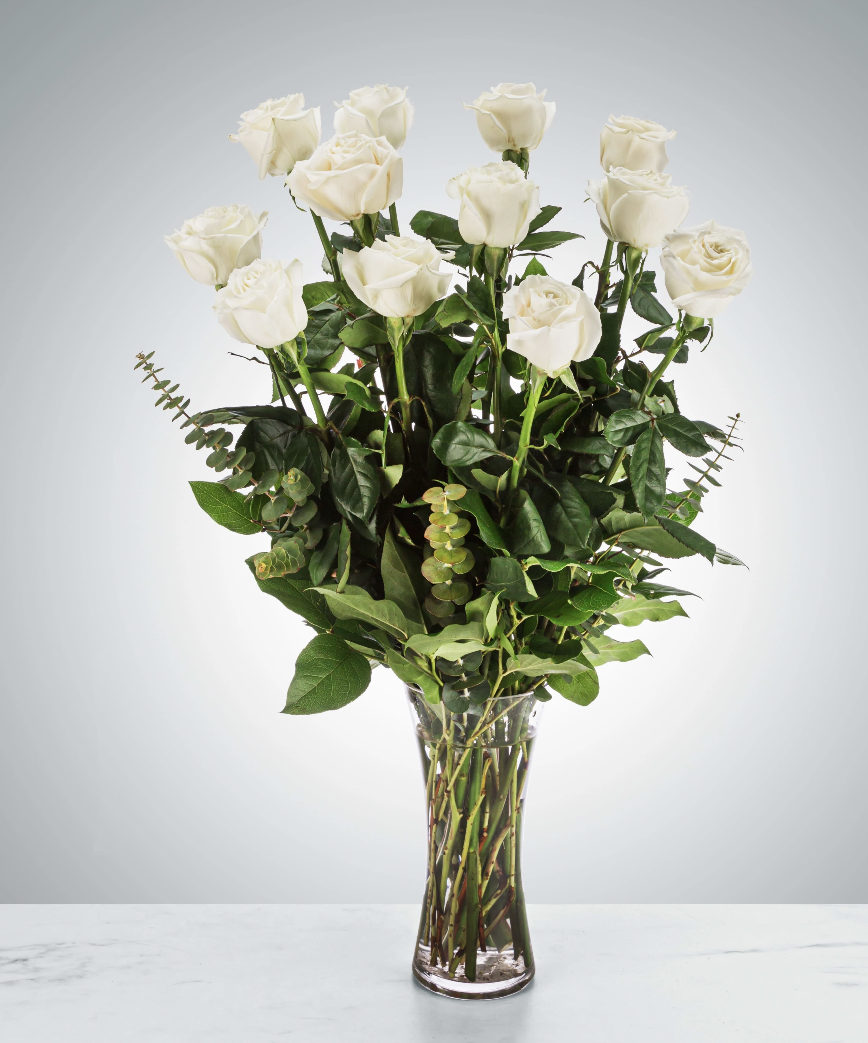 Dozen Long Stem White Roses by BloomNation™ - A dozen white roses are a classic gift! Perfect for Valentine's Day, an Anniversary, or any type of celebration.  Approximate Dimensions: 20"D x 30"H
