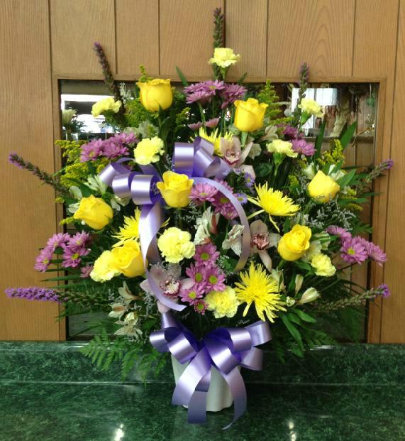 Large mixed bouquet with yellow roses and purple flowers in a vase
