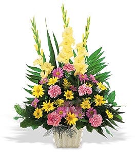 Yellow gladiolus and pink-yellow mixed flowers in a vase