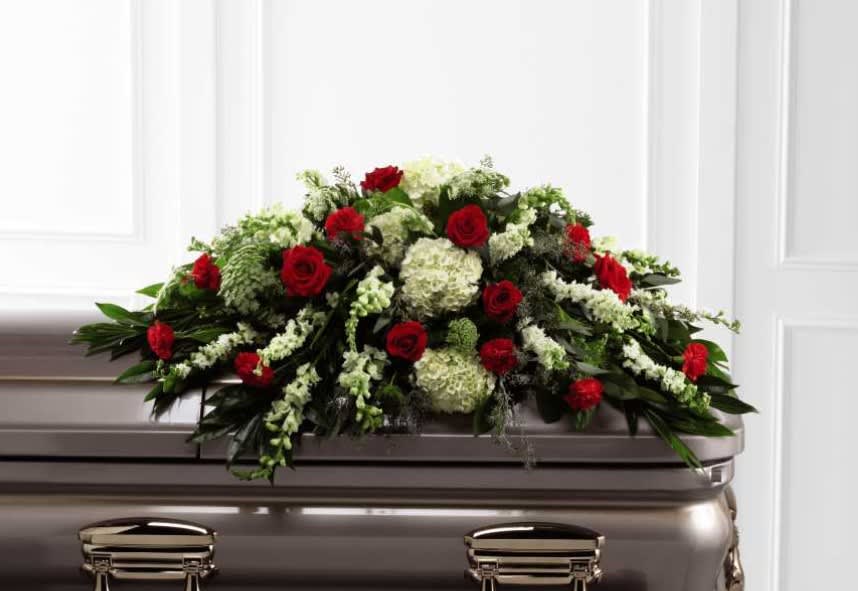 Red roses and white flowers arranged on a casket