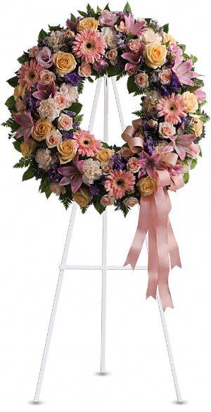 Pastel floral wreath on a white easel with a pink ribbon