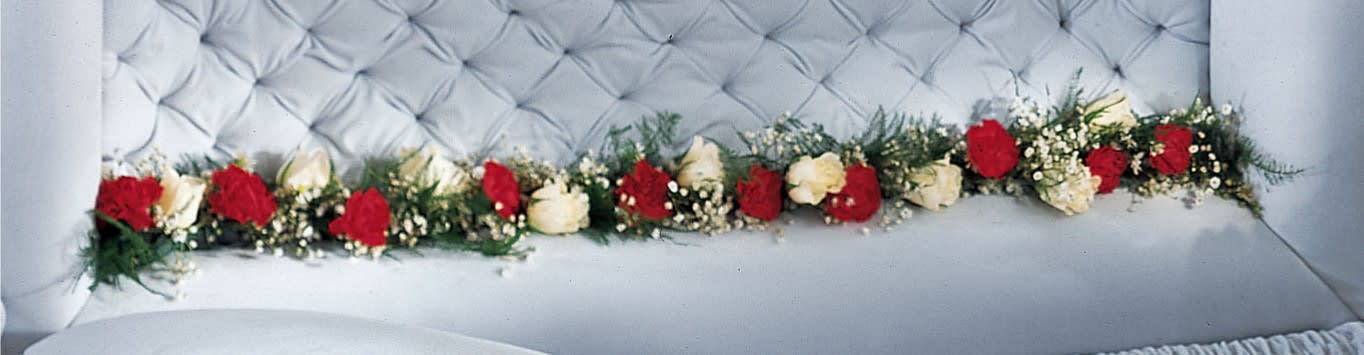 Long floral garland of red and white roses on a tufted white surface