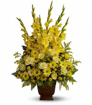 Tall yellow floral arrangement in a brown urn vase
