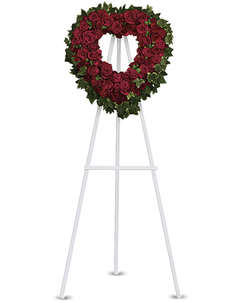 Blessed Heart - Make a strong, stylish statement of love with this beautiful heart-shaped wreath. Presented on a funeral easel, the rich red rose sympathy arrangement is a lovely standing spray to place on the altar or by the entrance to the service. Standard size 18" diameter form used. Deluxe size 24" diameter form used. 