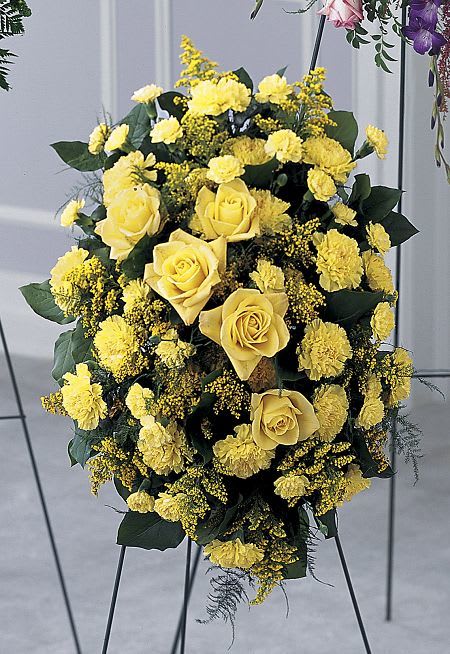 Yellow roses and carnations in a standing floral spray