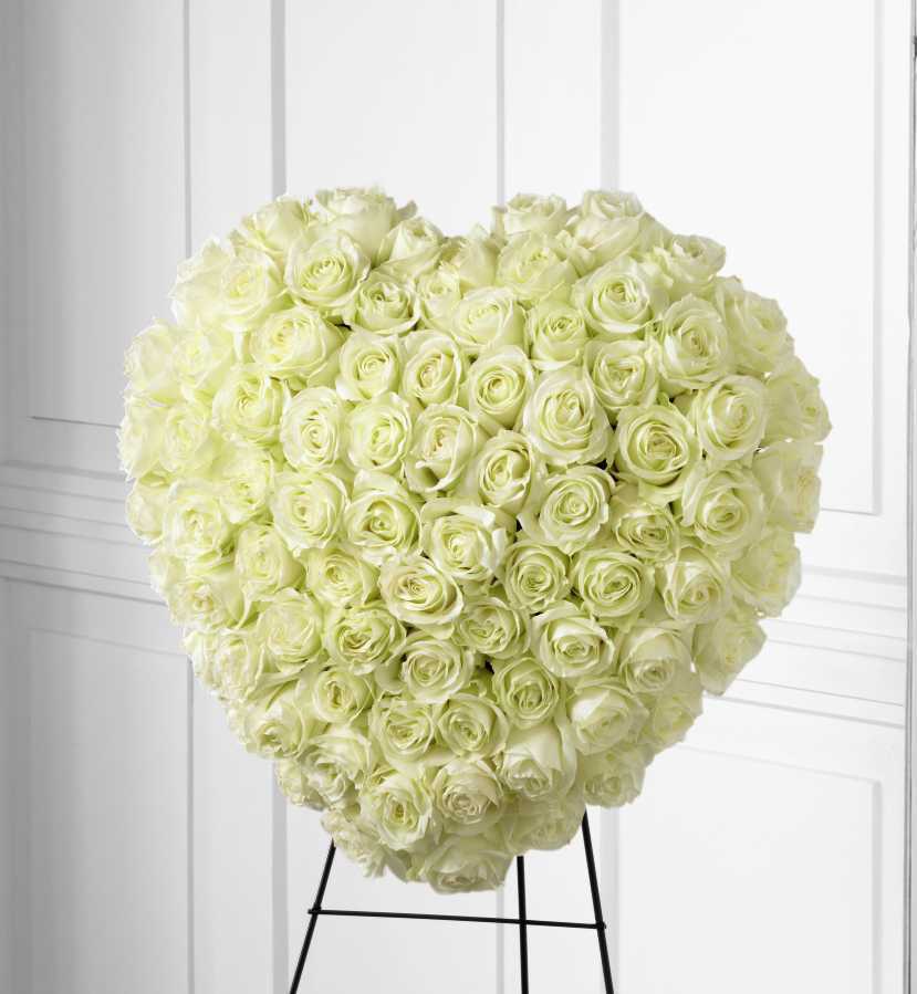 Heart-shaped arrangement of white roses on a stand