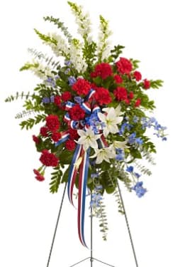 Standing floral spray with red, white, and blue flowers on an easel