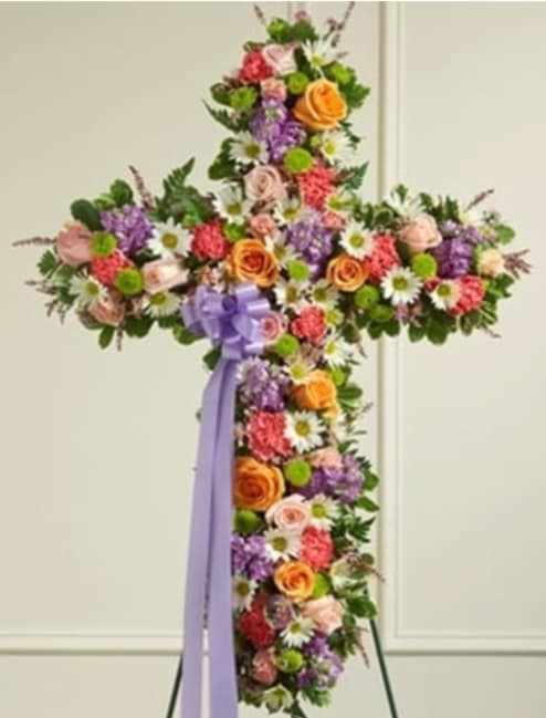 Cross-shaped floral standing spray with a purple ribbon